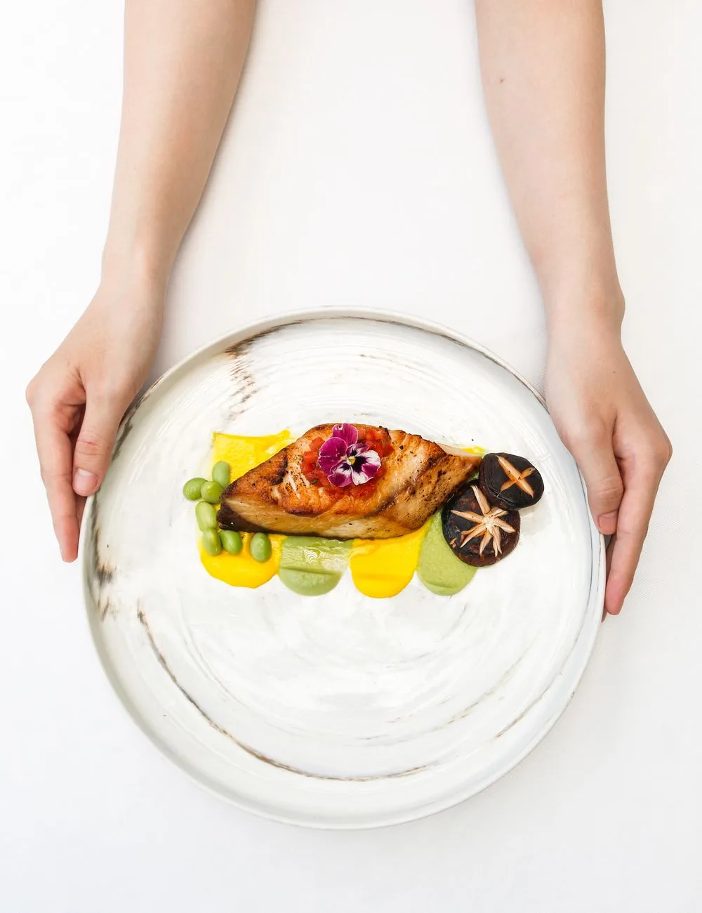Assiette signature du Komo : capitaine grillé, purées de saison et fleurs comestibles