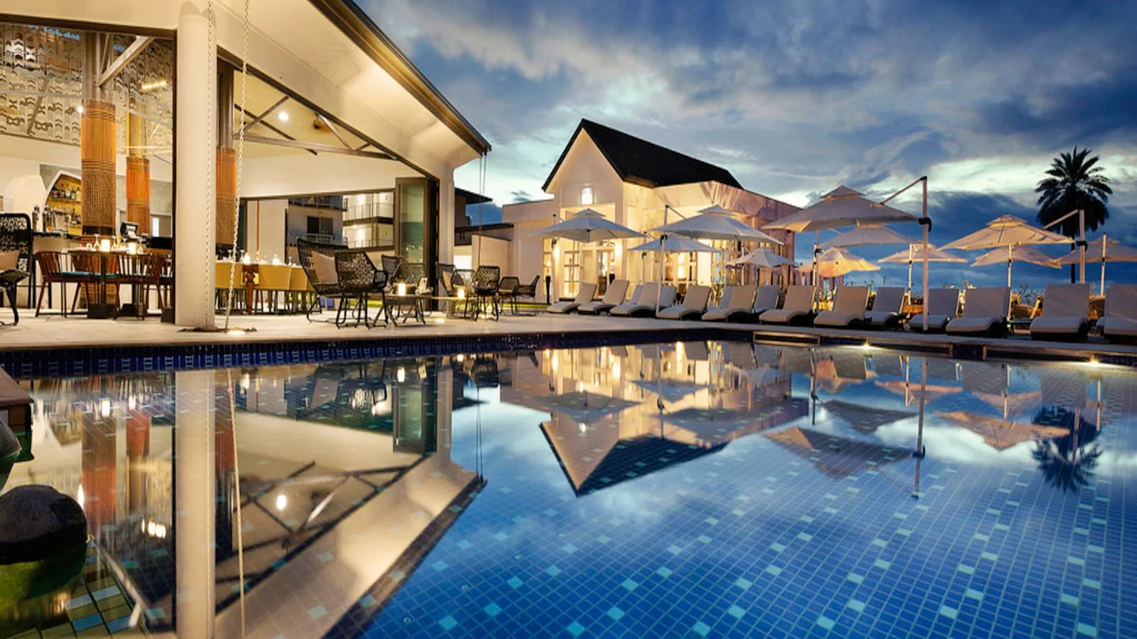 La piscine à débordement de l'Hôtel Olympe au crépuscule, face à l'océan